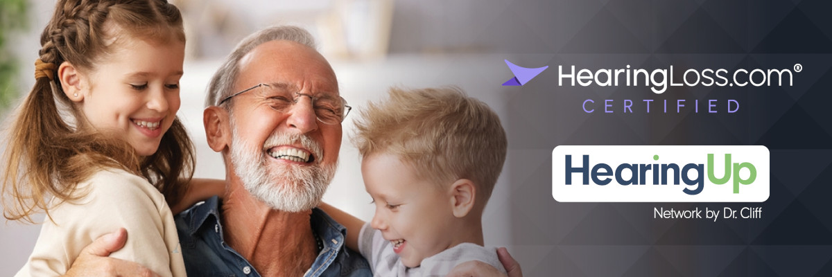 A mean hugging his grandchildren. HearingLoss.com and HearingUp logos are also featured overlaying the photo