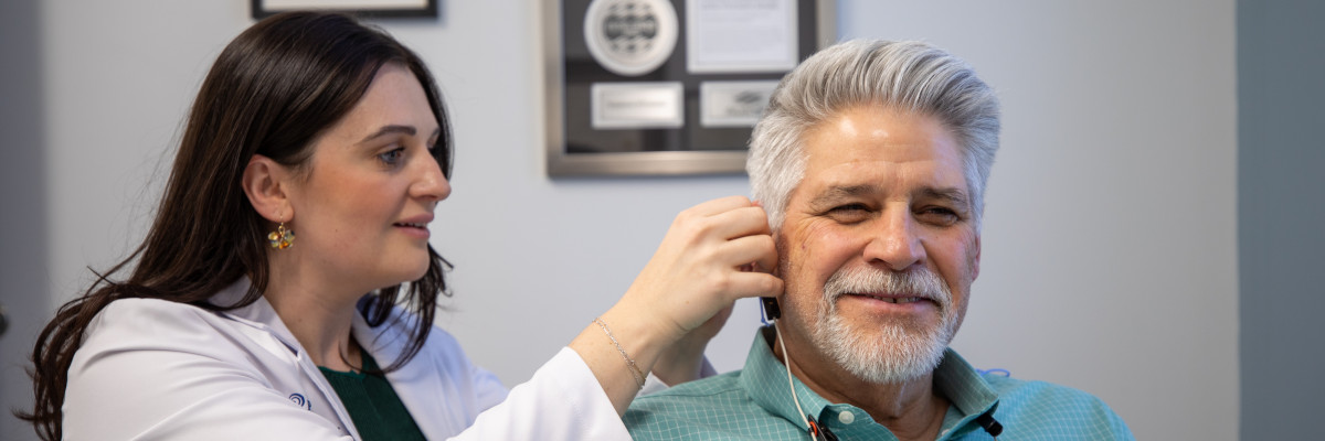 Dr. Olivia Patterson performing a hearing aid fitting on a patient